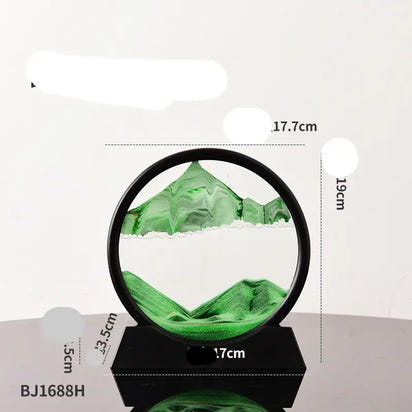 Green sand art in a black circular frame on a black base.