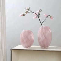 Two pink, swirled glass vases.