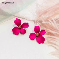 Two magenta flower earrings.