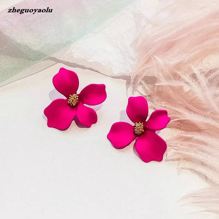 Two magenta flower earrings.