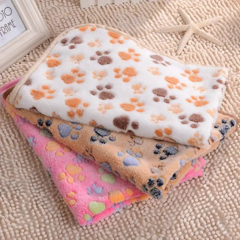 Stacked paw-print fleece blankets.