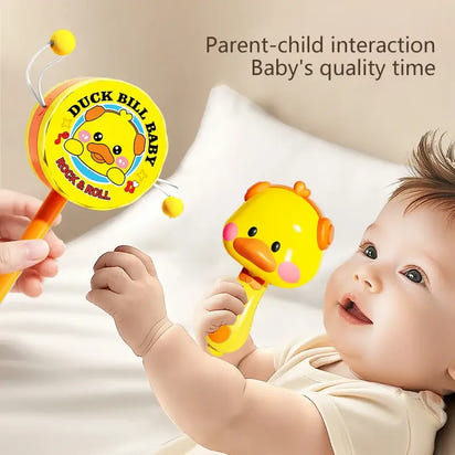 Baby playing with a duckbill baby rattle toy on a soft surface.