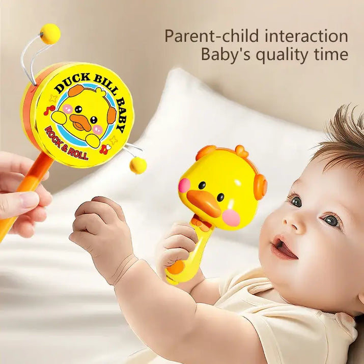 Baby playing with a duckbill baby rattle toy on a soft surface.