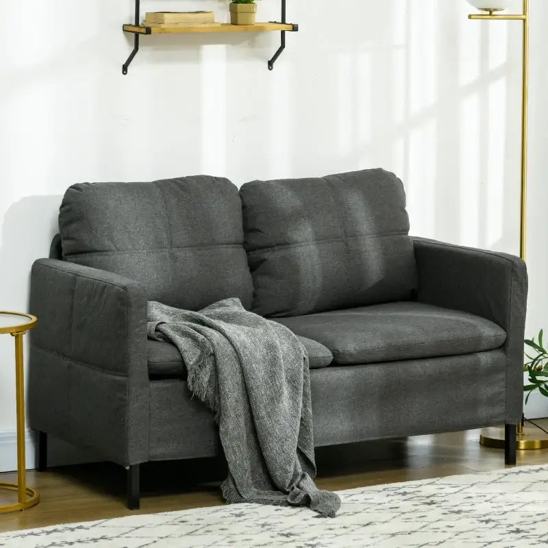 Gray loveseat with throw.