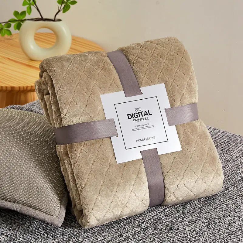 Beige quilted throw blanket.