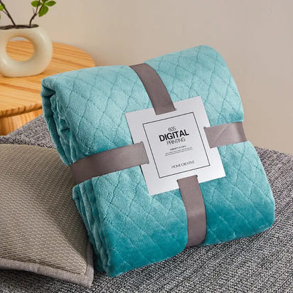 Turquoise quilted blanket with gray ribbon.