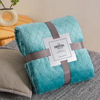Turquoise quilted blanket with gray ribbon.