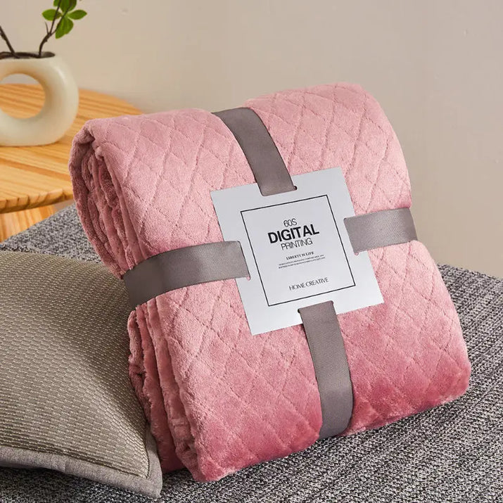 Pink quilted blanket with gray ribbon.