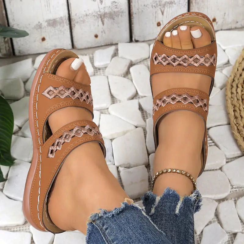 Brown leather sandals with decorative stitching.