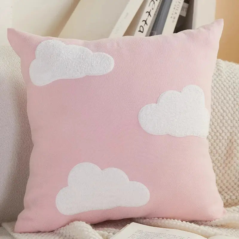 Pink pillow with white cloud appliqués.