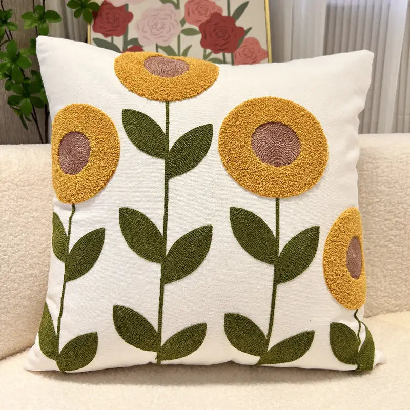 White decorative pillow with embroidered sunflowers.