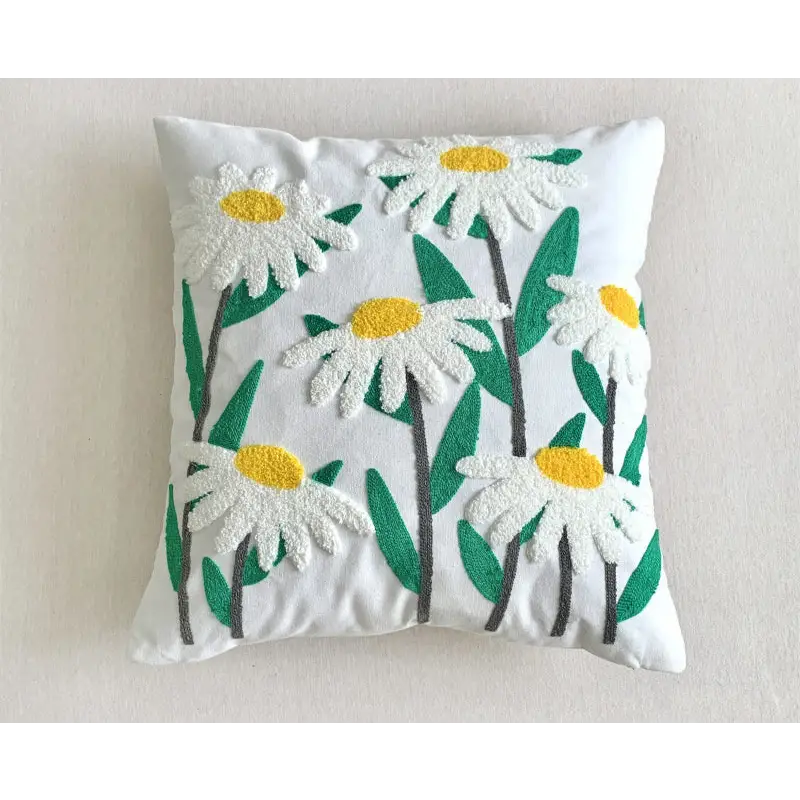 White daisy-embroidered throw pillow.
