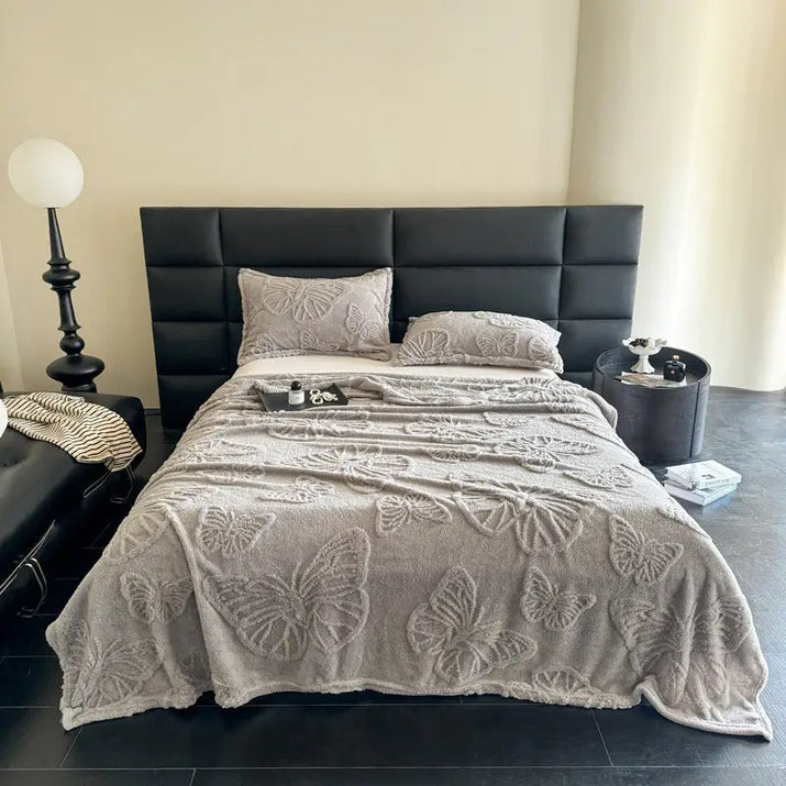 Butterfly-patterned gray bedspread.