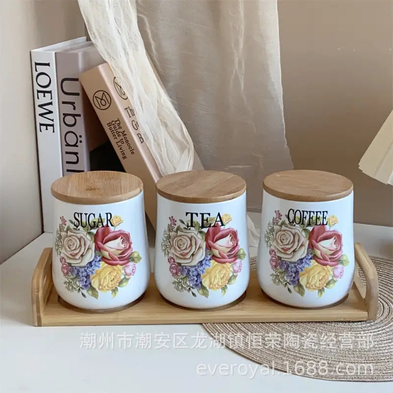 Floral-decorated ceramic canisters with wooden lids.