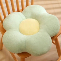 Green flower-shaped plush cushion with yellow center.