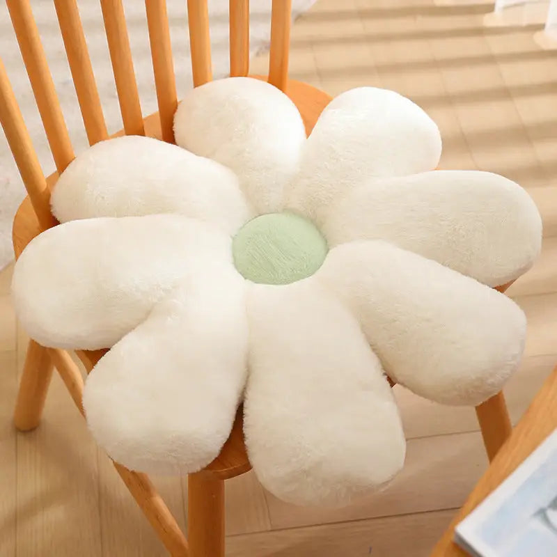 White daisy-shaped plush cushion with a green center.