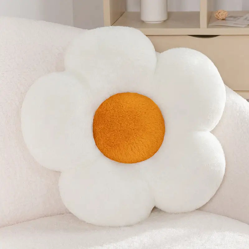 White flower-shaped plush pillow with orange center.