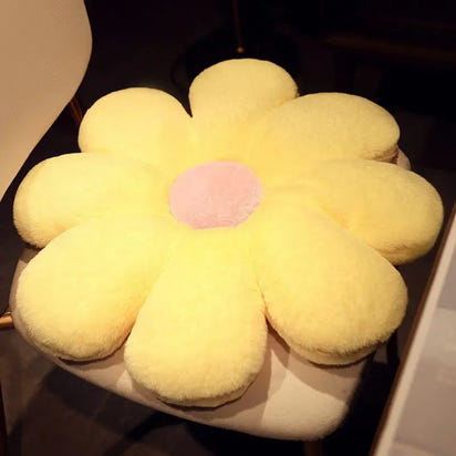 Yellow flower-shaped cushion with pink center.