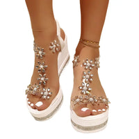 White platform wedge sandals with floral embellishments.