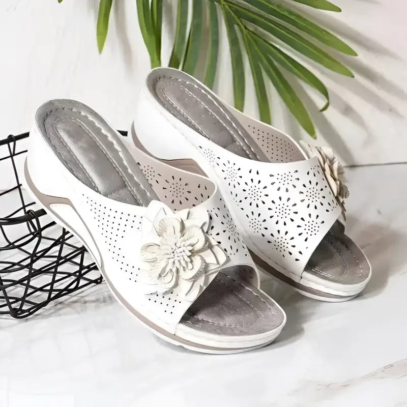 White floral-accented wedge sandals.