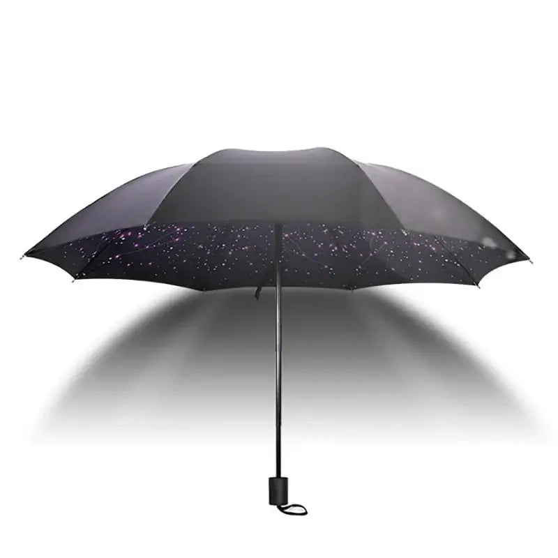 Open black umbrella with white speckles.