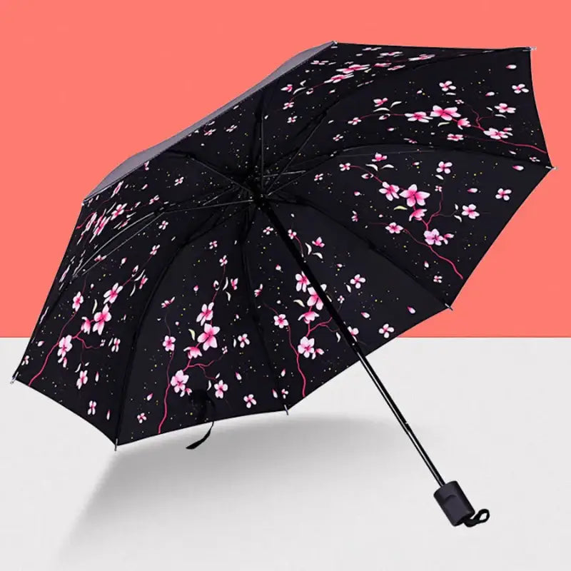 Black umbrella with pink floral pattern.