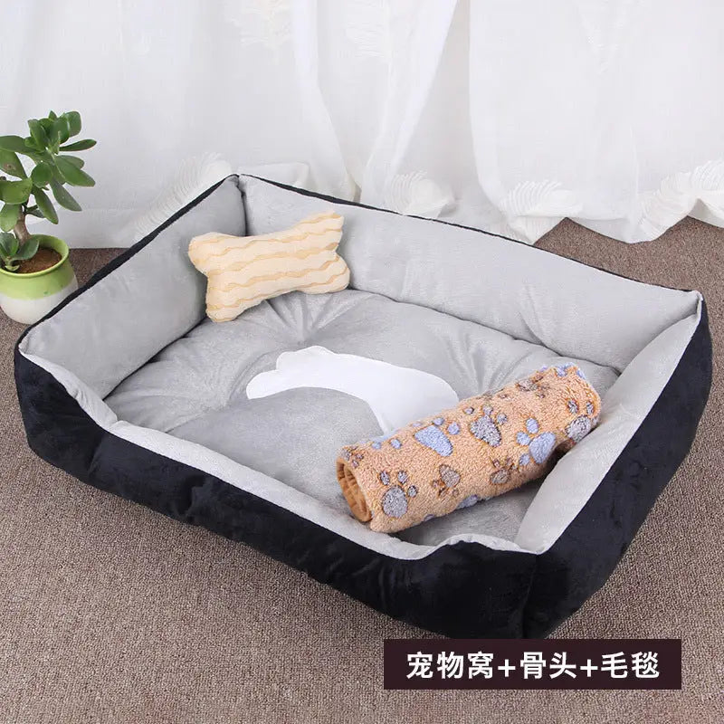 Black and gray dog bed with bone pillow and paw-print blanket.