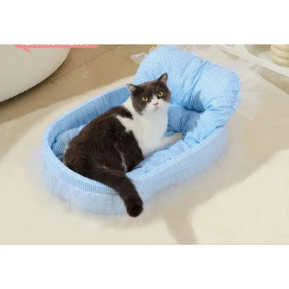 Blue, cushioned cat bed with a gray and white cat.