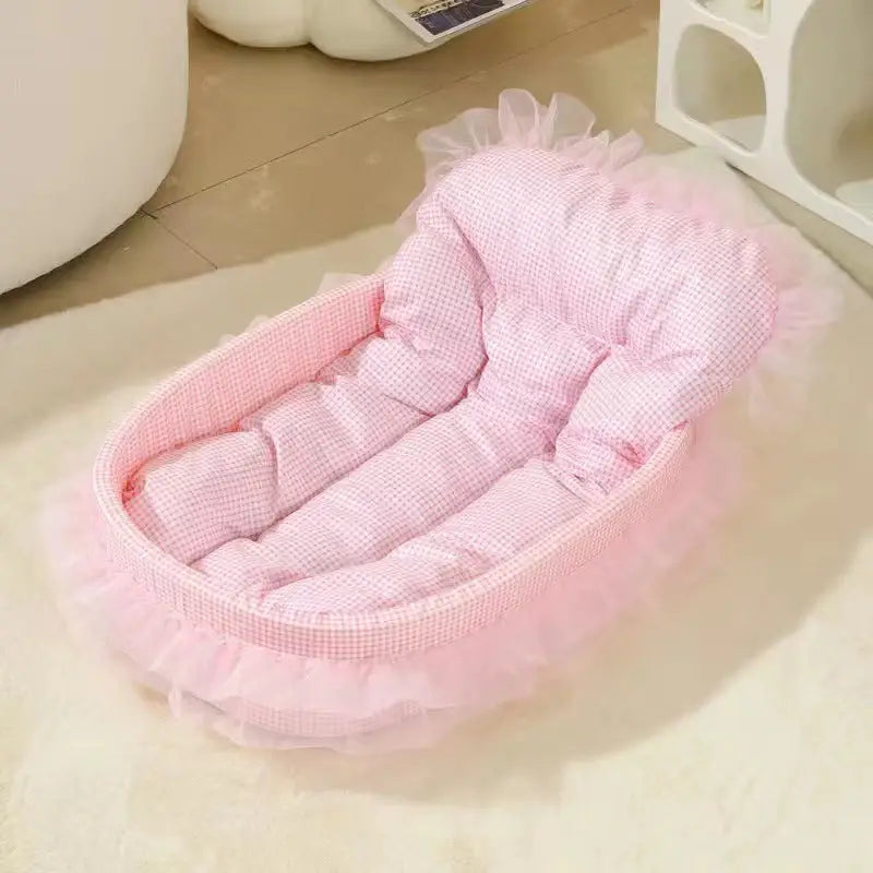 Pink, padded pet bed with frilly trim.