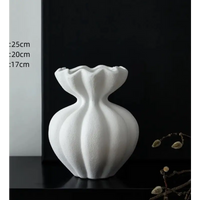 White ceramic vase with ruffled top.
