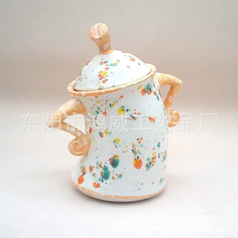 White ceramic sugar bowl with colorful splatters.