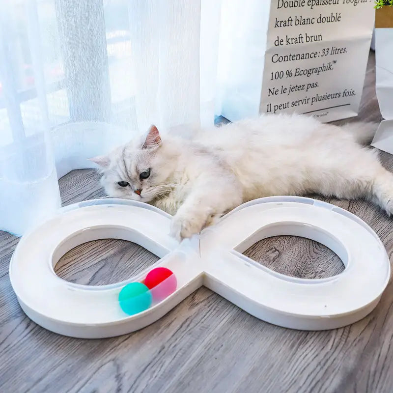 White infinity-shaped cat toy with colorful balls.