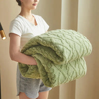 Soft green cable-knit blanket.