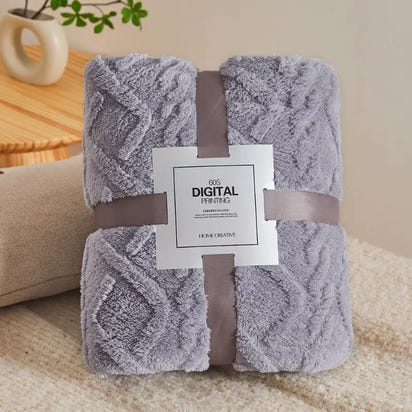 Gray plush blanket with ribbon and label.
