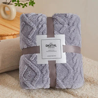 Gray plush blanket with ribbon and label.