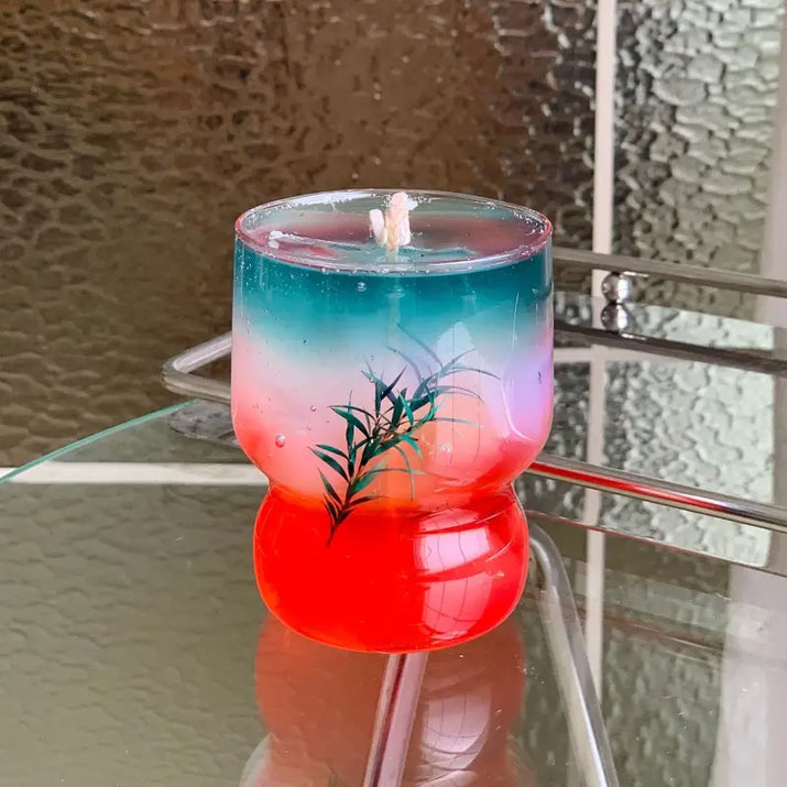Colorful layered candle in glass.