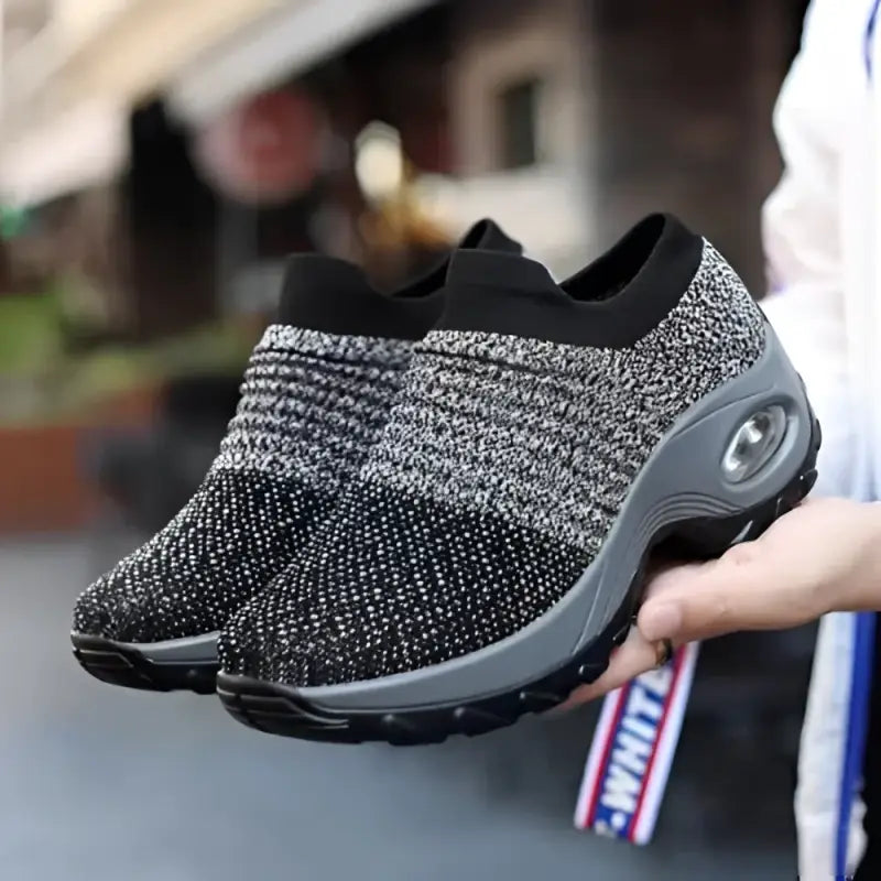 Gray and black knit slip-on sneakers.