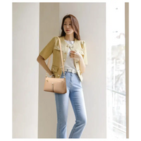 Woman’s light brown leather crossbody bag.