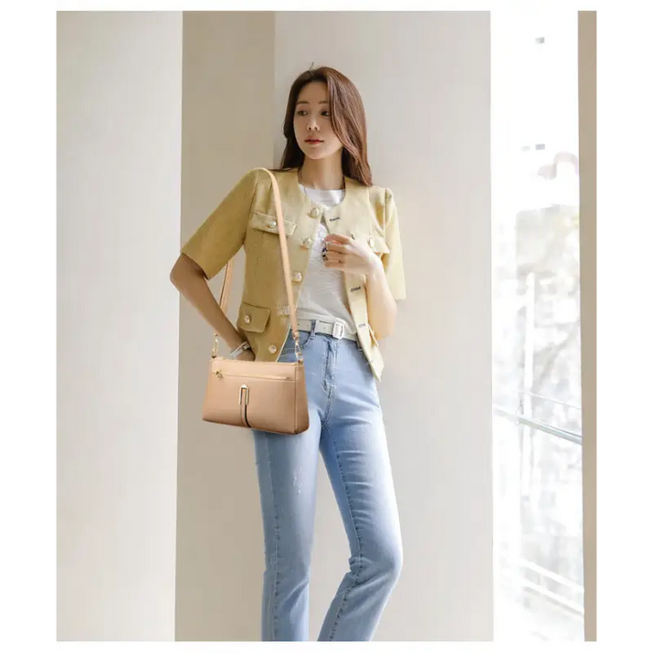 Woman’s light brown leather crossbody bag.