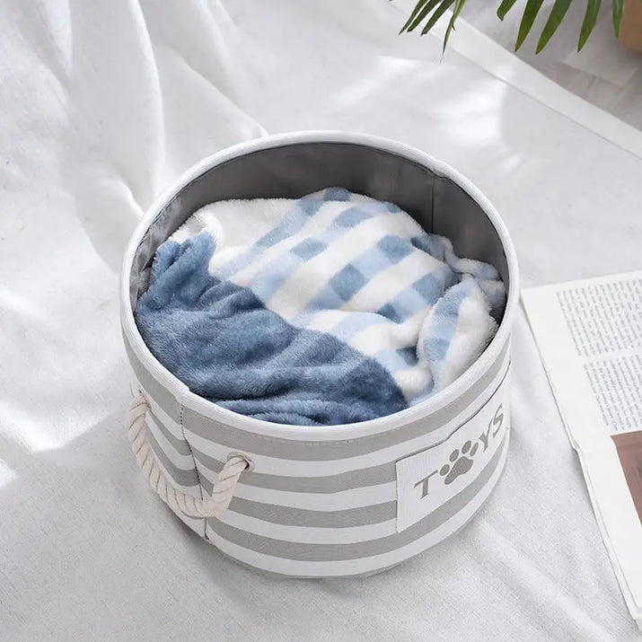 Striped round storage container with rope handles.