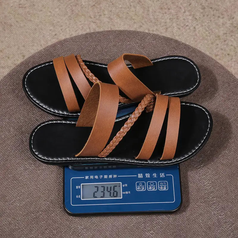 Pair of brown leather sandals on a digital scale.