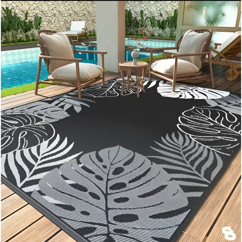 Black outdoor rug with leaf pattern.