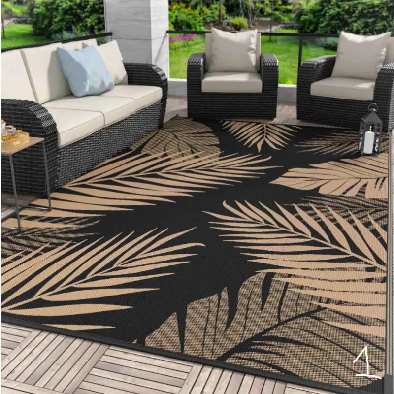 Black and tan palm leaf outdoor rug.