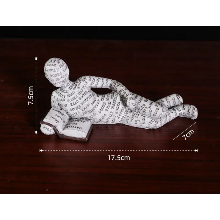 Figurine of a person reading a book.