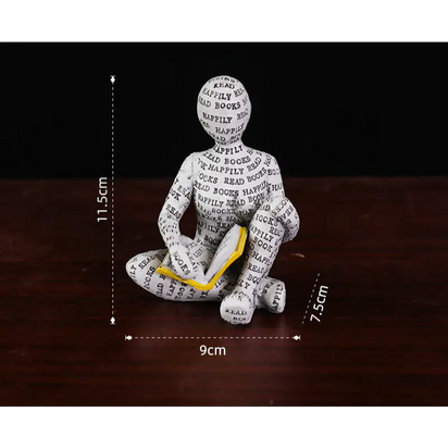 Figurine of a person reading a book.