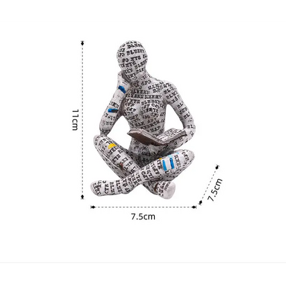 Figurine of a seated reader covered in text.