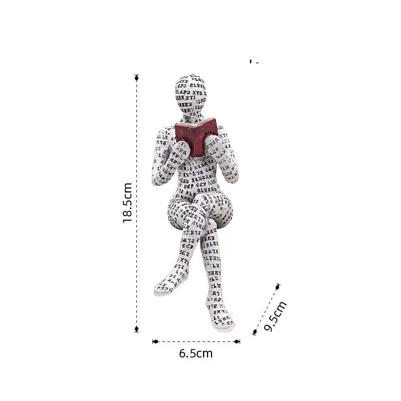 Figurine of a seated person covered in text, reading a book.
