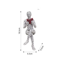 Figurine of a seated person covered in text, reading a book.