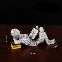 Figurine of a person reading a book.