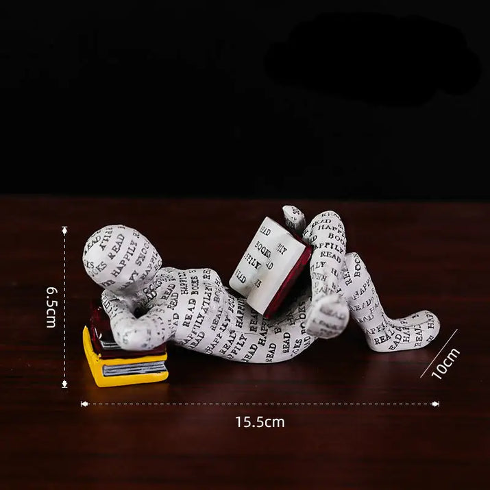 Figurine of a person reading a book.
